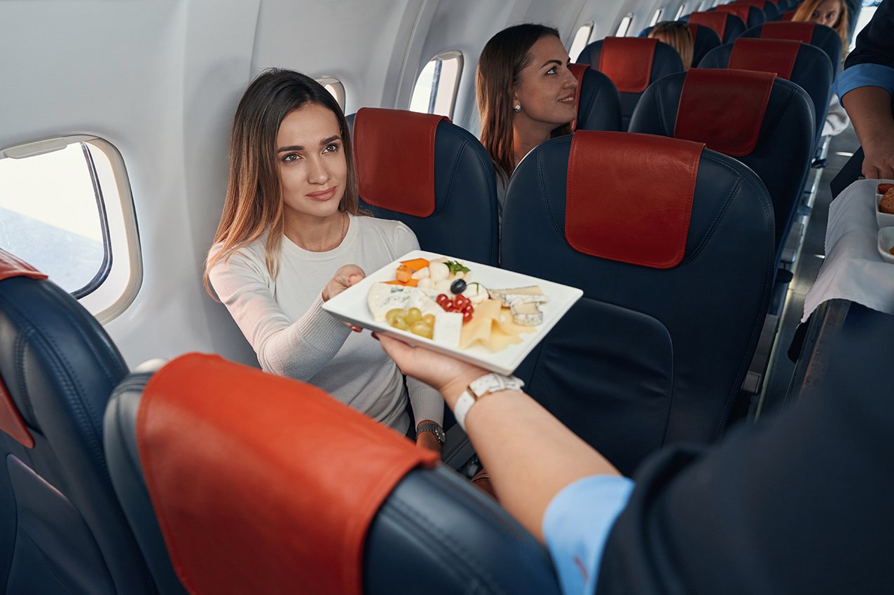 Woman in aircraft cabin getting her meal